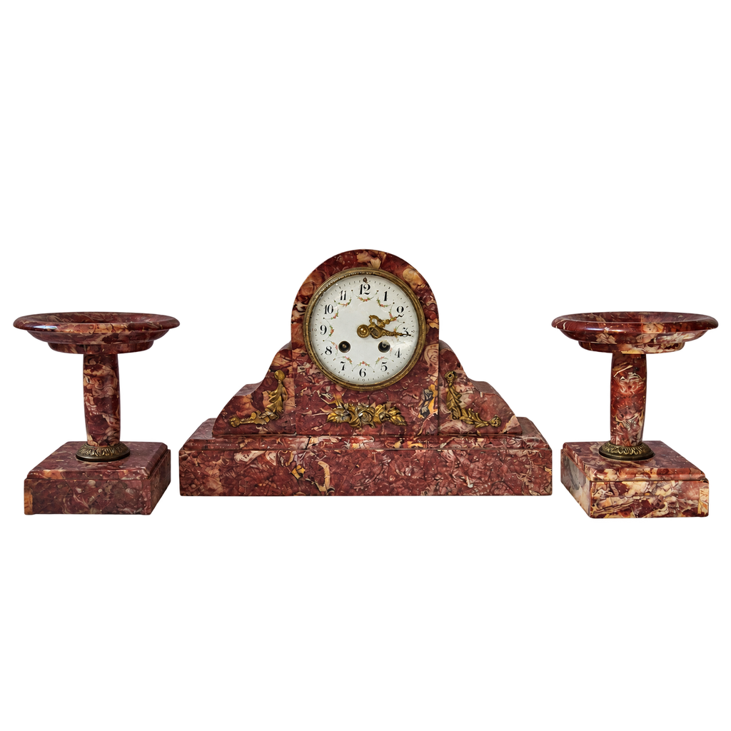 Garniture de cheminée en marbre rouge veiné : pendule centrale et deux coupes assorties, vue de face sur fond transparent.